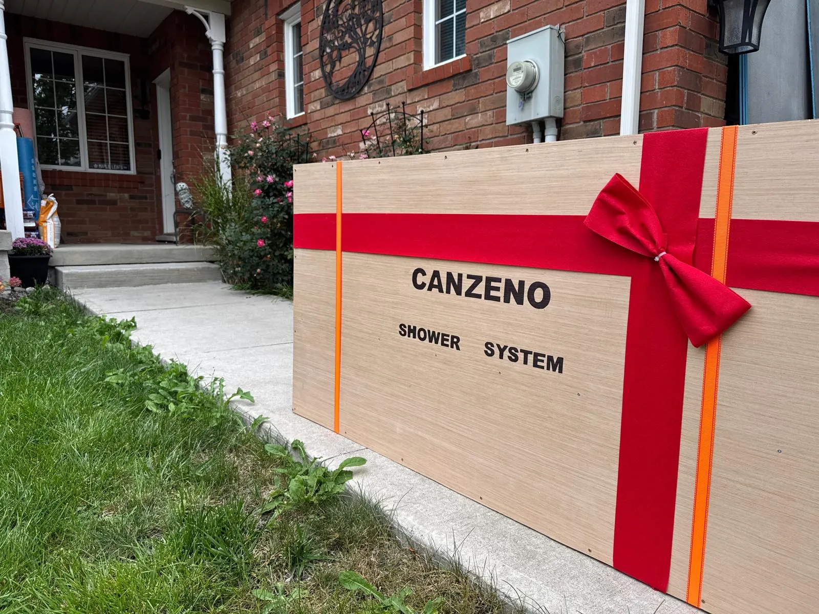 A Canzeno shower system packed in a wooden crate with a red ribbon, delivered to a customer’s home
