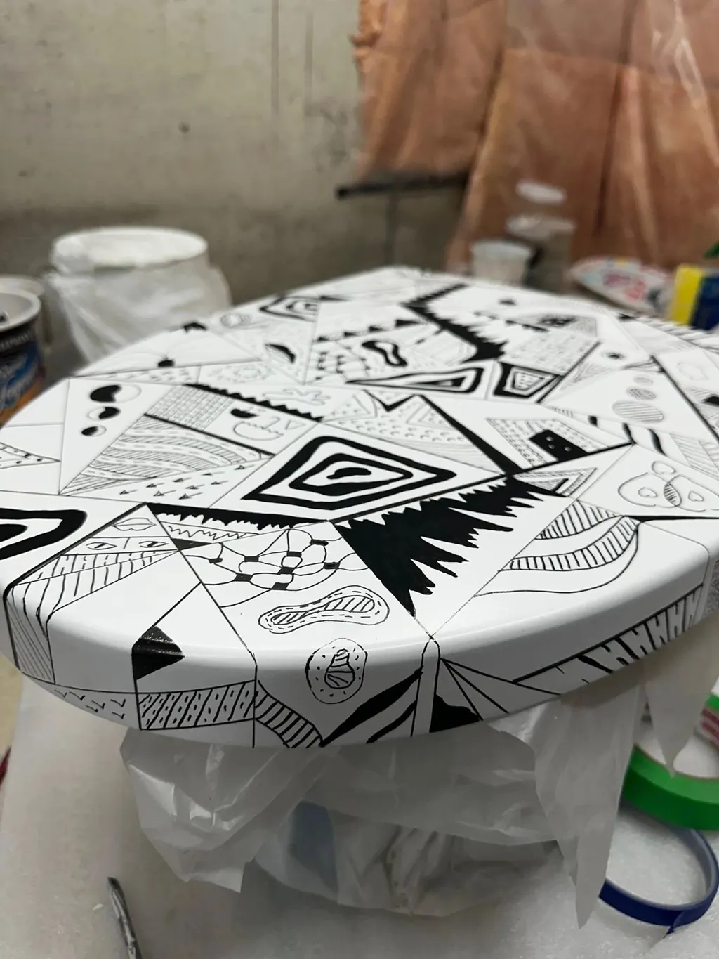 Bathtub being hand-painted with a black-and-white pattern in the Canzeno workshop