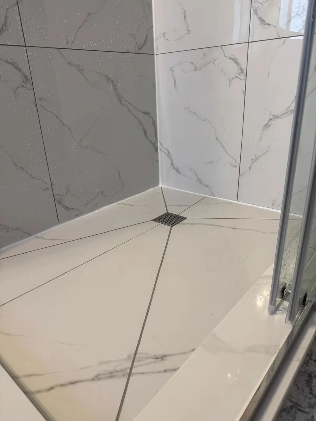 Square drain shower base with a corner drain and sloped tile cuts