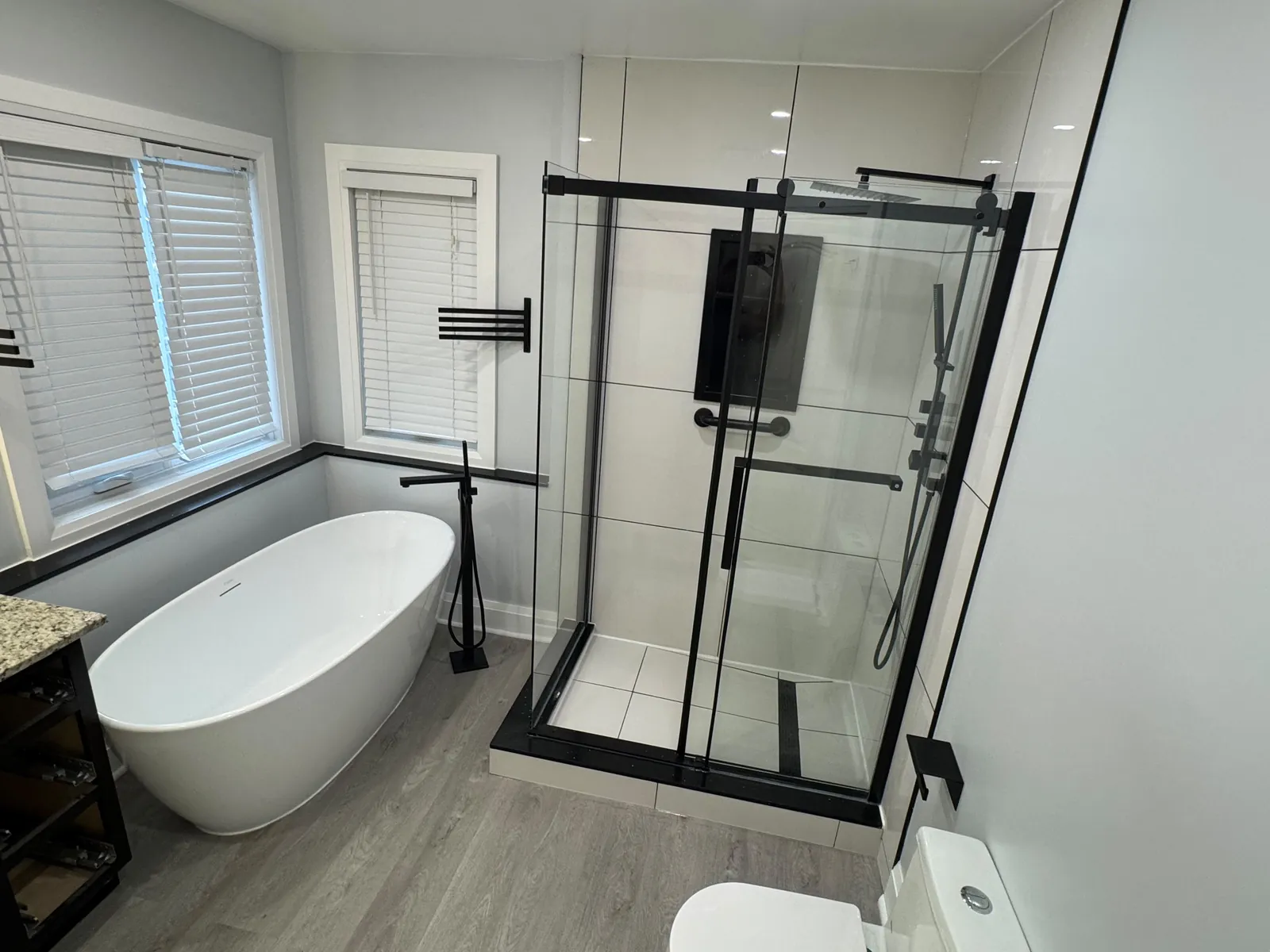 Full bathroom renovation in Pickering by Canzeno, black-framed shower and freestanding tub